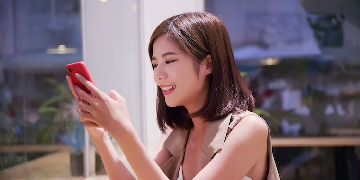 スマートフォンを操作する笑顔の女性