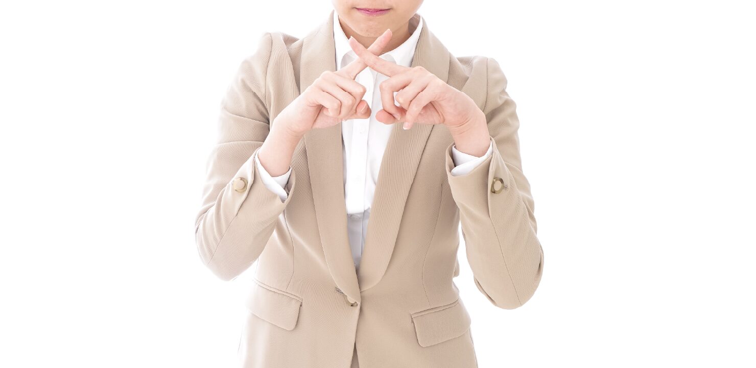 手でバツを作っている女性