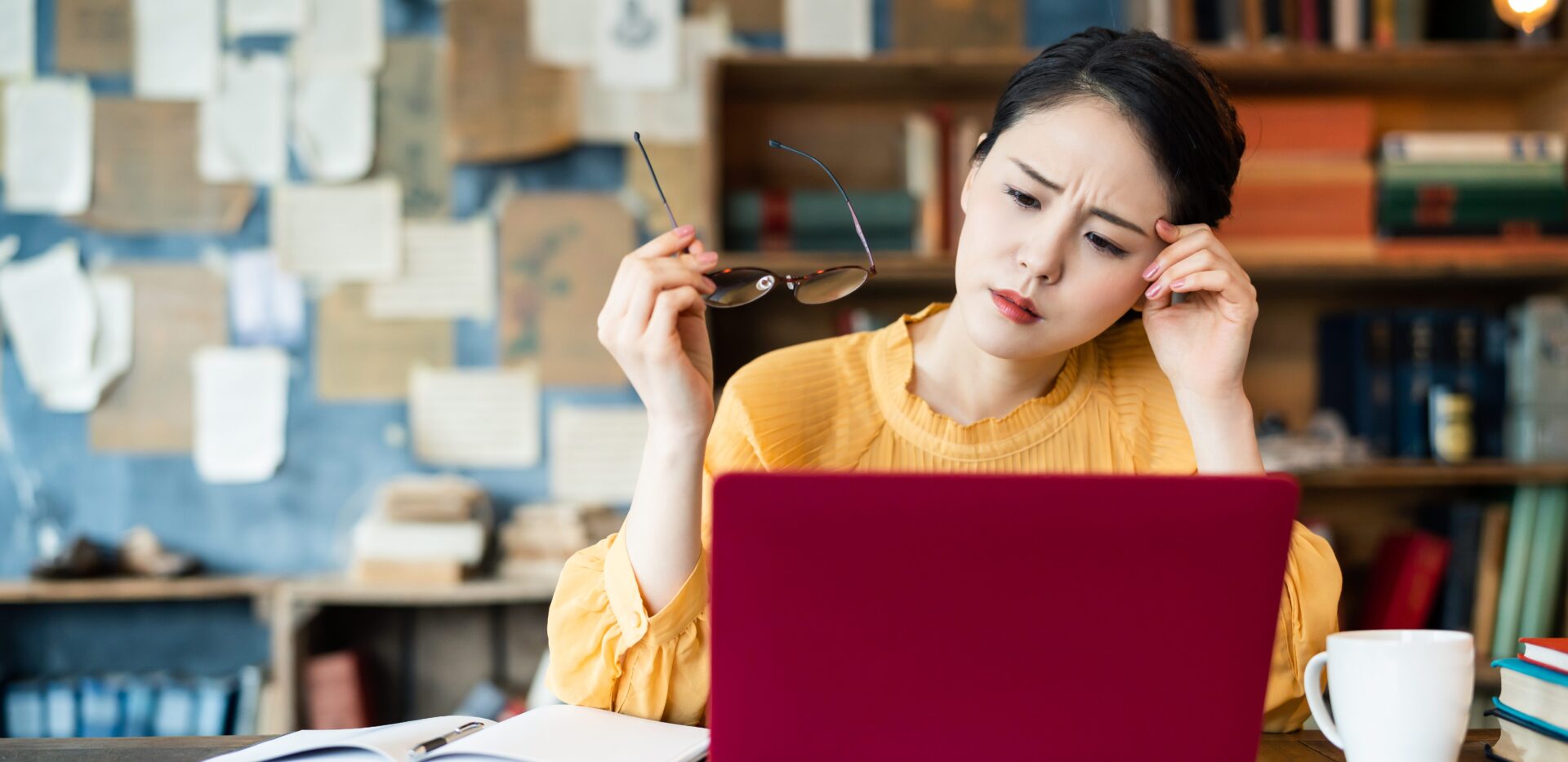PCの前で悩んでいる女性