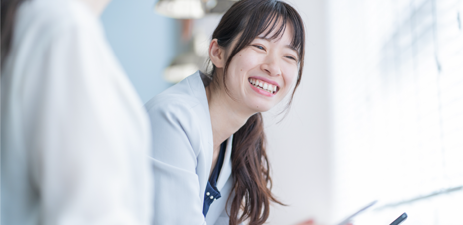 スマホを手に持っている笑顔の女性