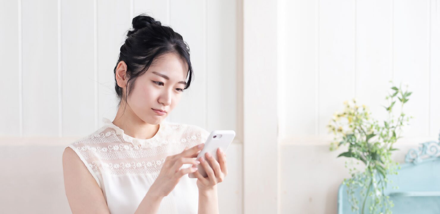 スマホを見て困っている女性