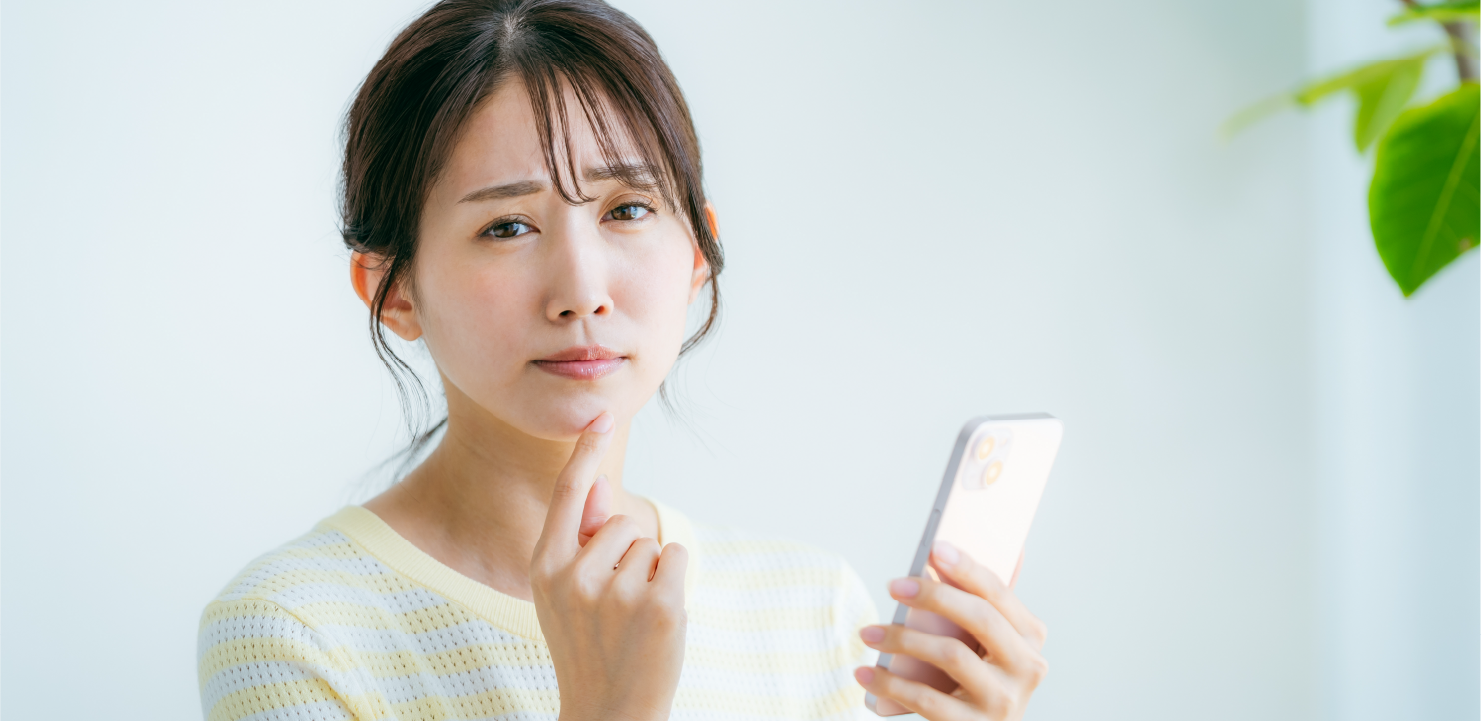 スマホを持って困っている女性