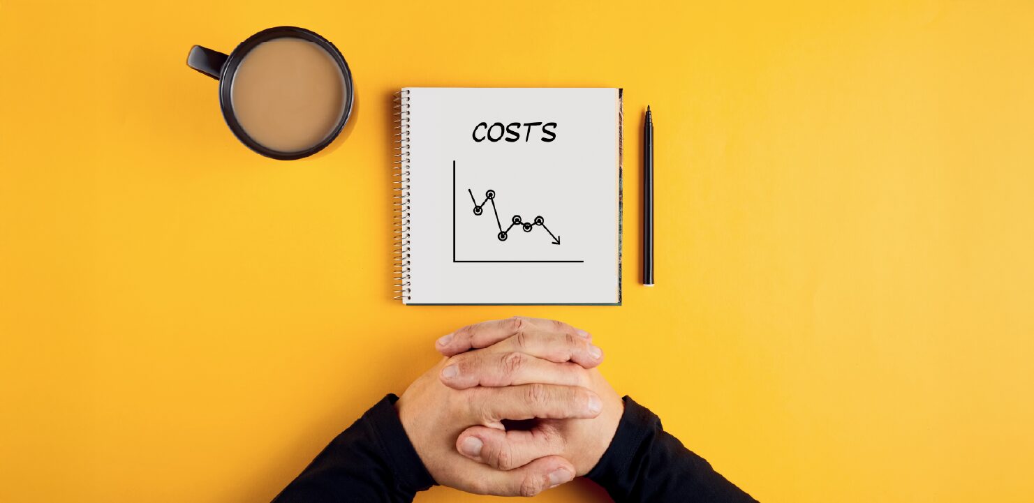 COSTSと書かれているノートと手を組んでいる人