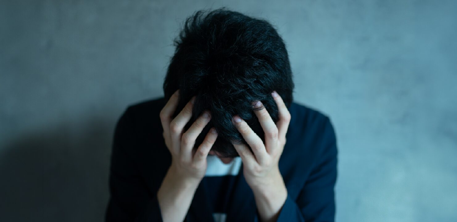 頭を抱えている男性
