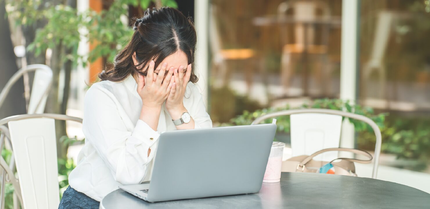 ノートPCの前で頭を抱える女性